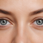 Close-up of a woman's eyes with blue irises and light brown skin.